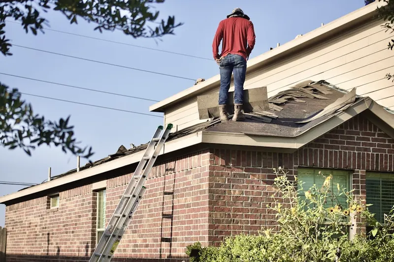 Professional roofer working on a residential roof in Dumas